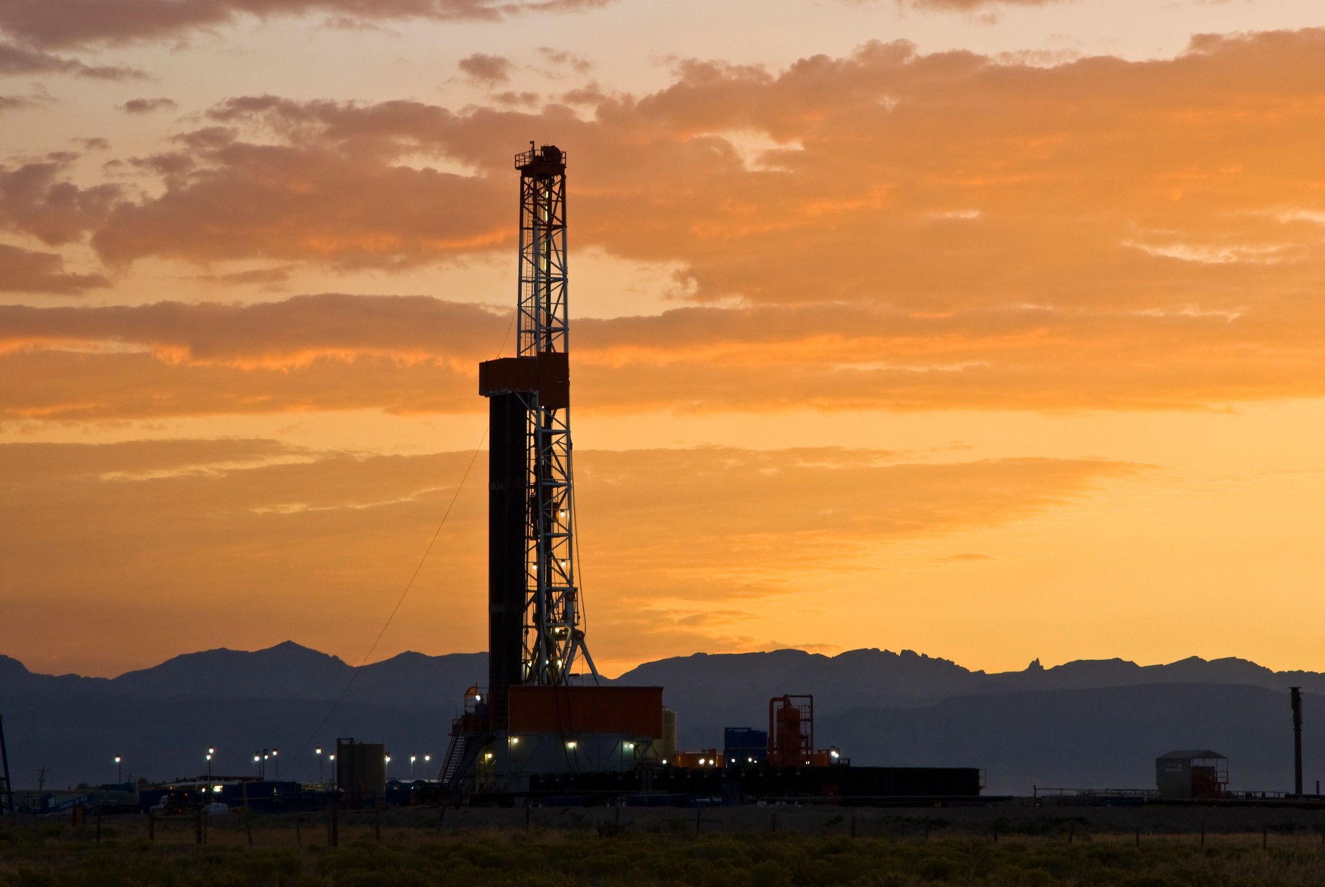 Oil drilling rig with a sunset in the background