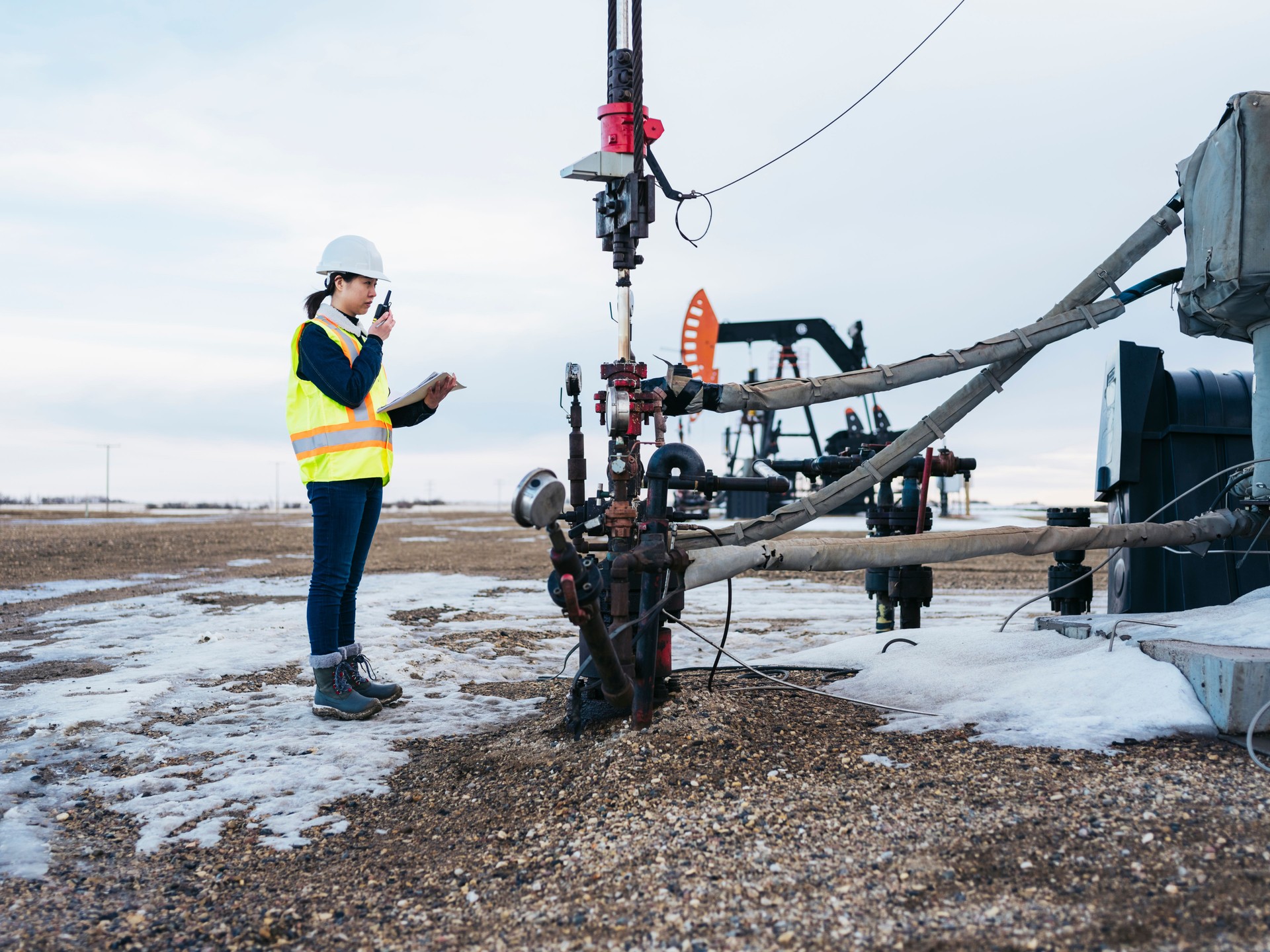Female Oil Worker working at oil field with talkie
