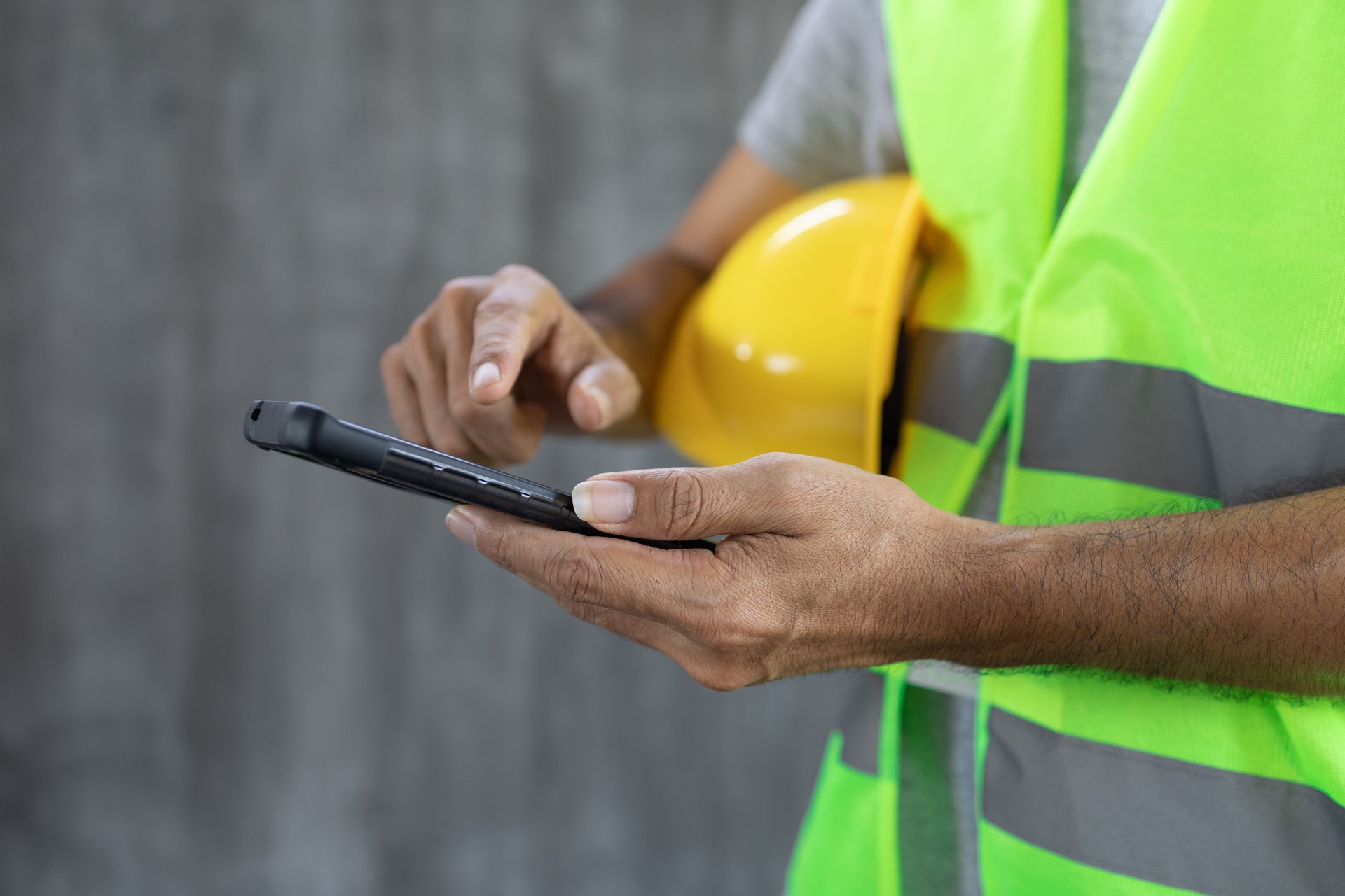 Close up Construction worker hands Touch screen smartphone
